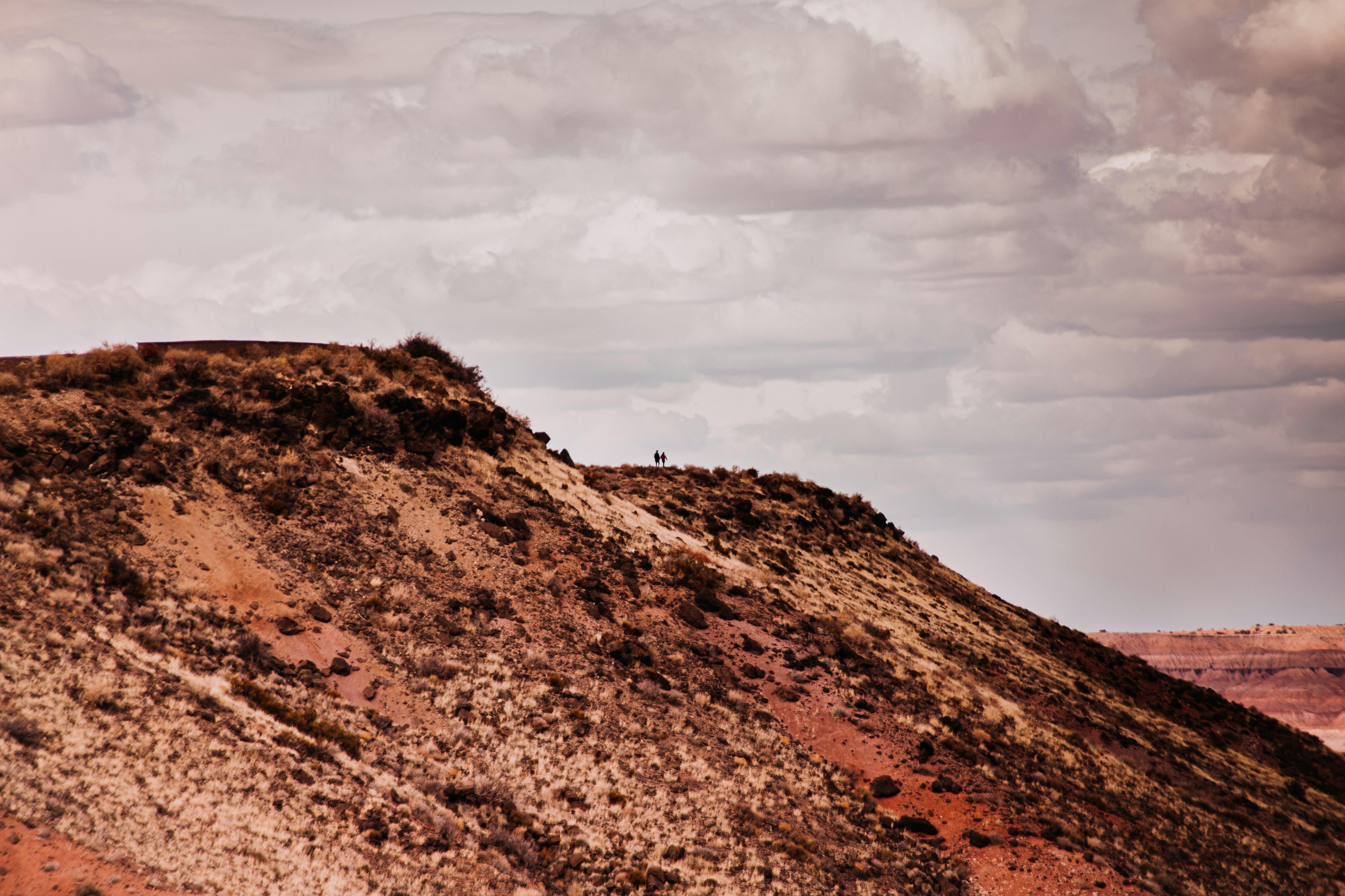 brown mountain under white clouds during daytime